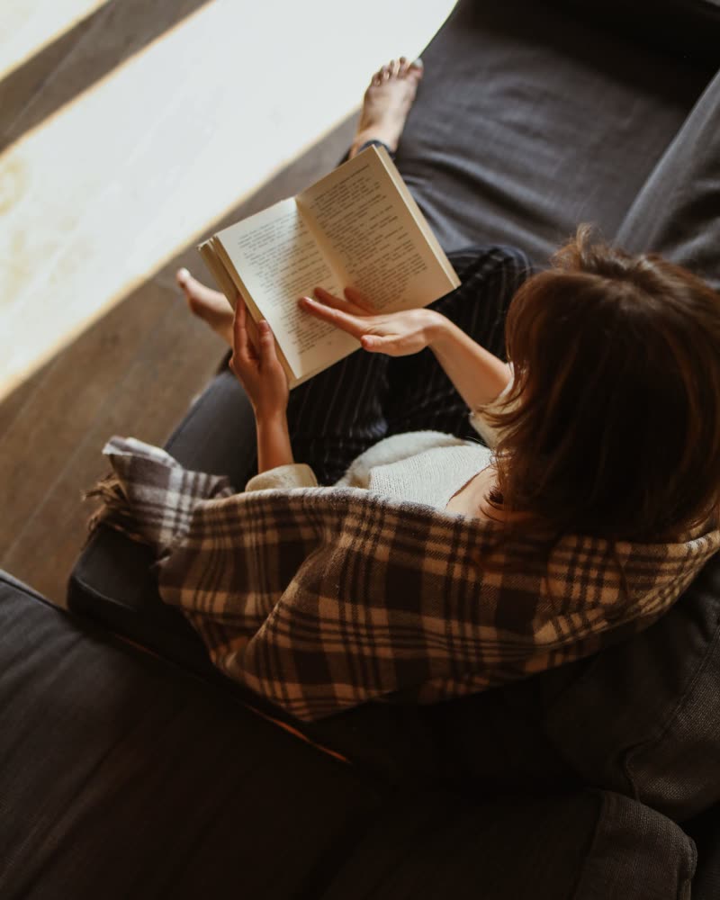 Mujer leyendo tranquila en el sofá